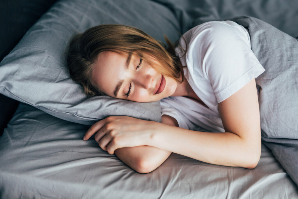 Femme endormie qui se repose dans un lit confortable