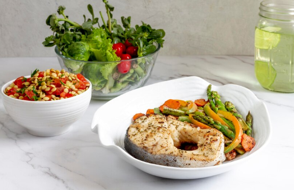 Assiette gourmande composée de poisson frais et de légumes de saison, illustrant une alimentation saine avec des produits bruts, sans sauces industrielles ni excès de matières grasses